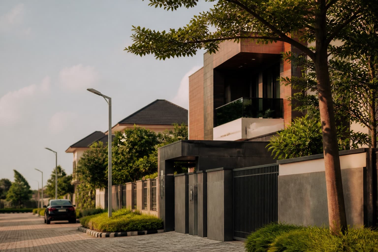Modern residential architecture along a tree-lined street in Nigeria